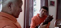 From My Reincarnation, Chogyal Namkhai Norbu examines a ritual object while his son, Khyentse Yeshi Namkhai looks on