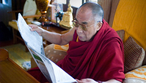 His Holiness the Dalai Lama reads a newspaper in The Sun Behind the Clouds.