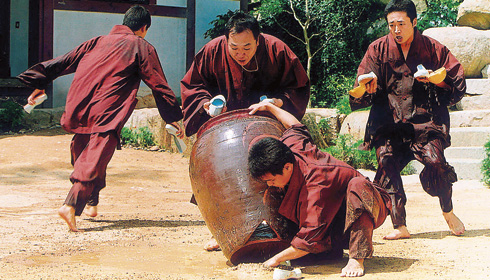 Korean monks scrambling to keep water in a broken urn.