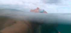 Namkhai Norbu Rinpoche floating in the ocean in Jennifer Fox's film, My Reincarnation