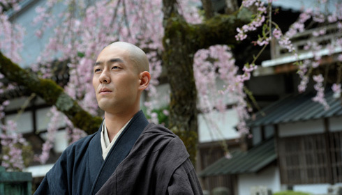 Zen monk Eihei Dogen standing in front of cherry blossoms in the film Zen.